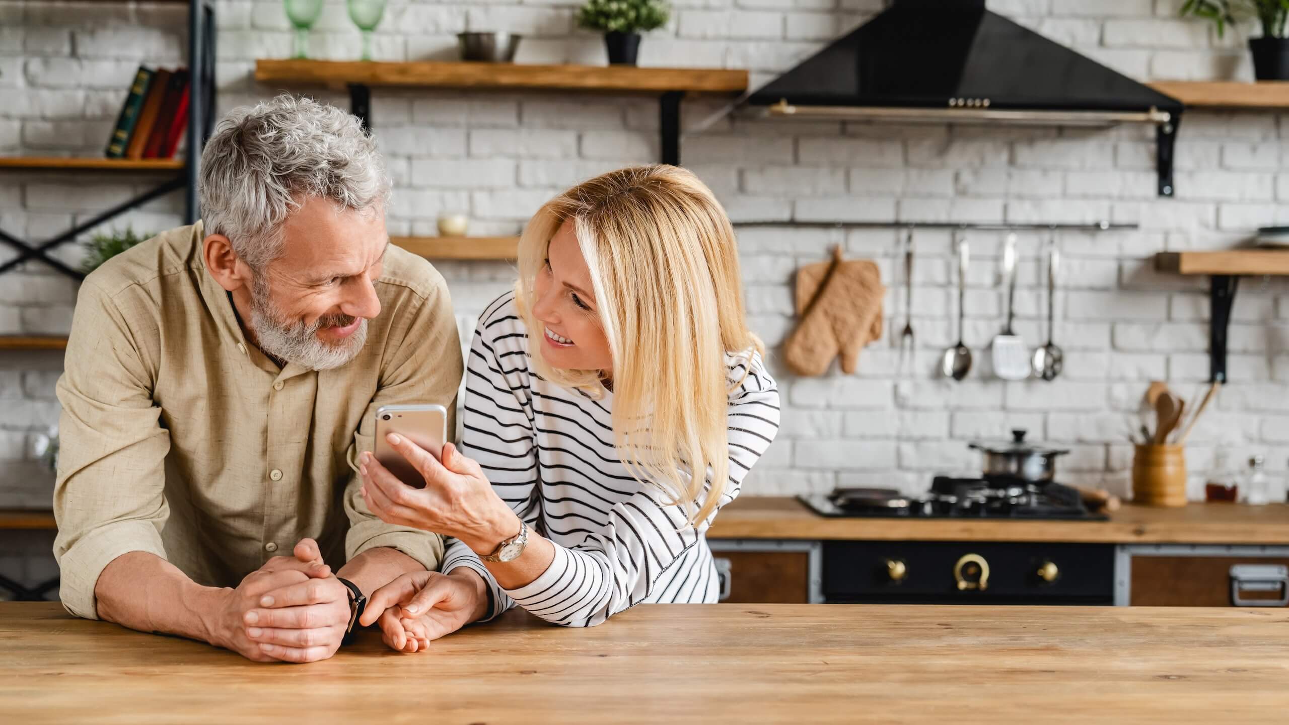 Man and women in a kitchen on smart phone