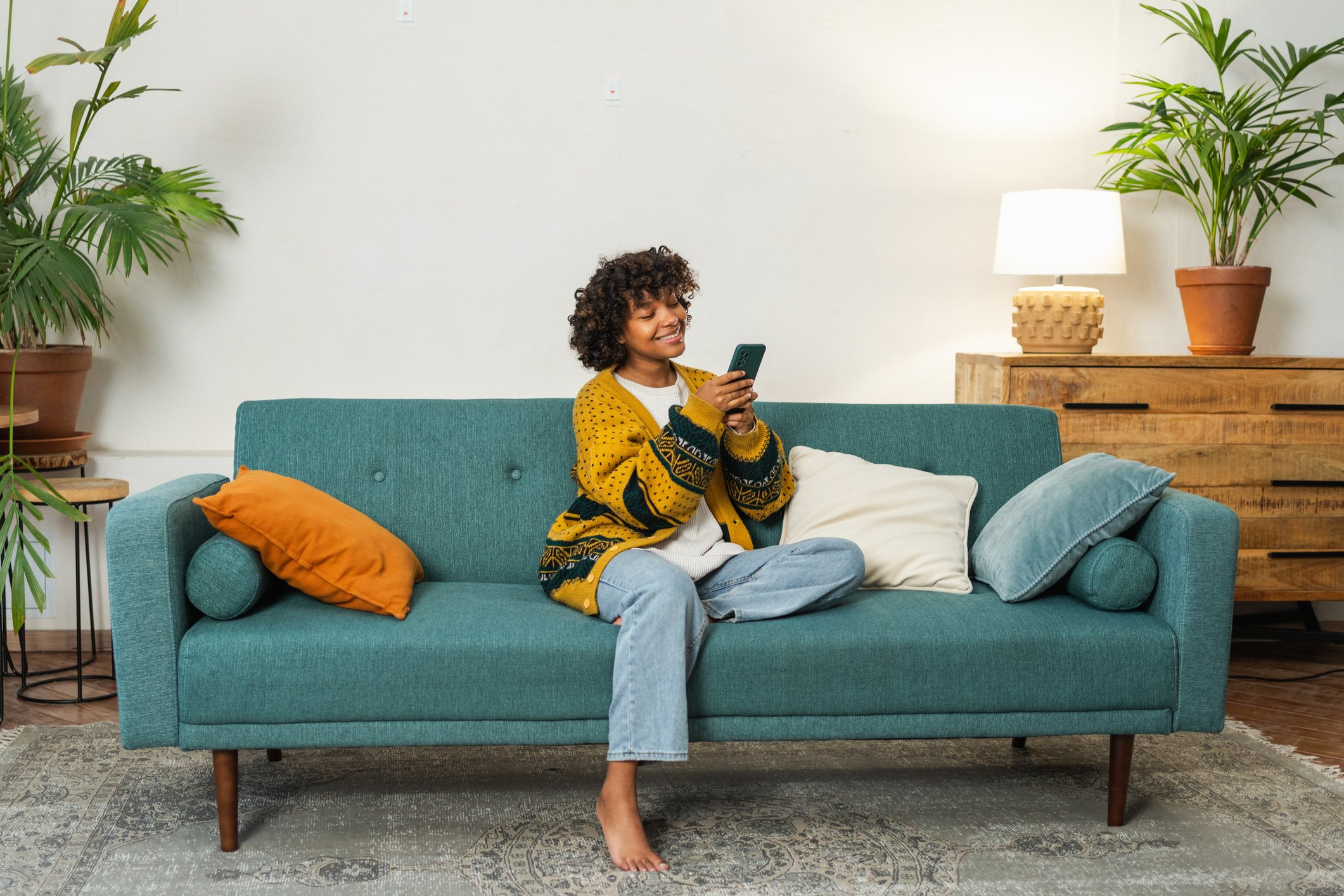 lady sitting on sofa looking at smart phone