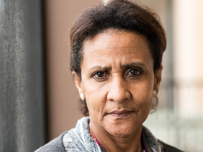 A close up of a middle aged woman who is looking directly into the camera. She looks worried.