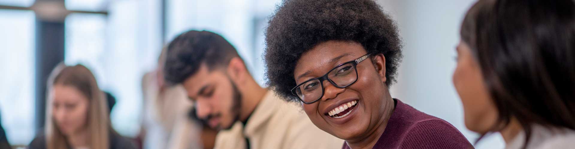 A woman smiling and talking to a fellow student